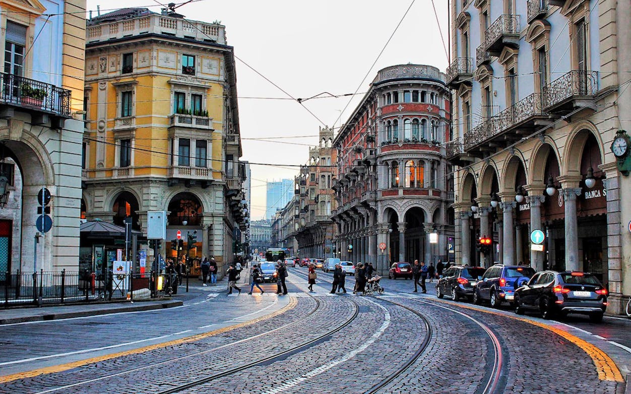 Street view in Turin with historic buildings and tram tracks.