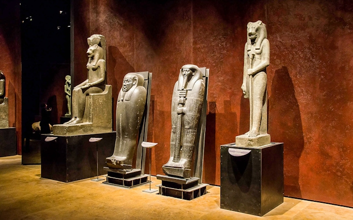 Ancient Egyptian statues and sarcophagi displayed in the Egyptian Museum.
