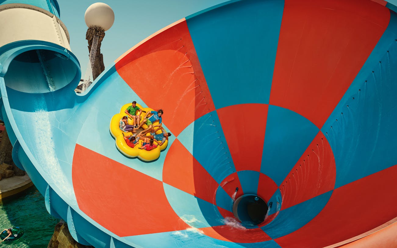 Group enjoying a water slide at Yas Waterworld, Abu Dhabi, during winter offer.