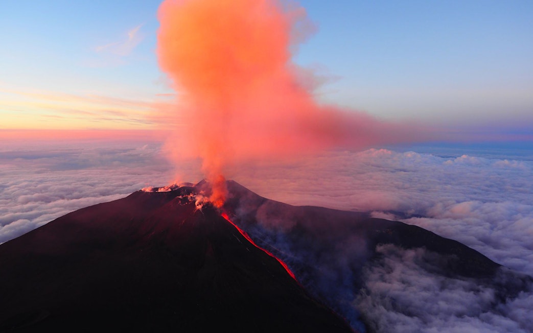 Mount Etna erupting with smoke and lava flow, Catania, Italy.
