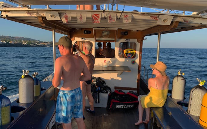Jeep tour participants on a boat near Catania, preparing for Etna Park and Acitrezza excursion.