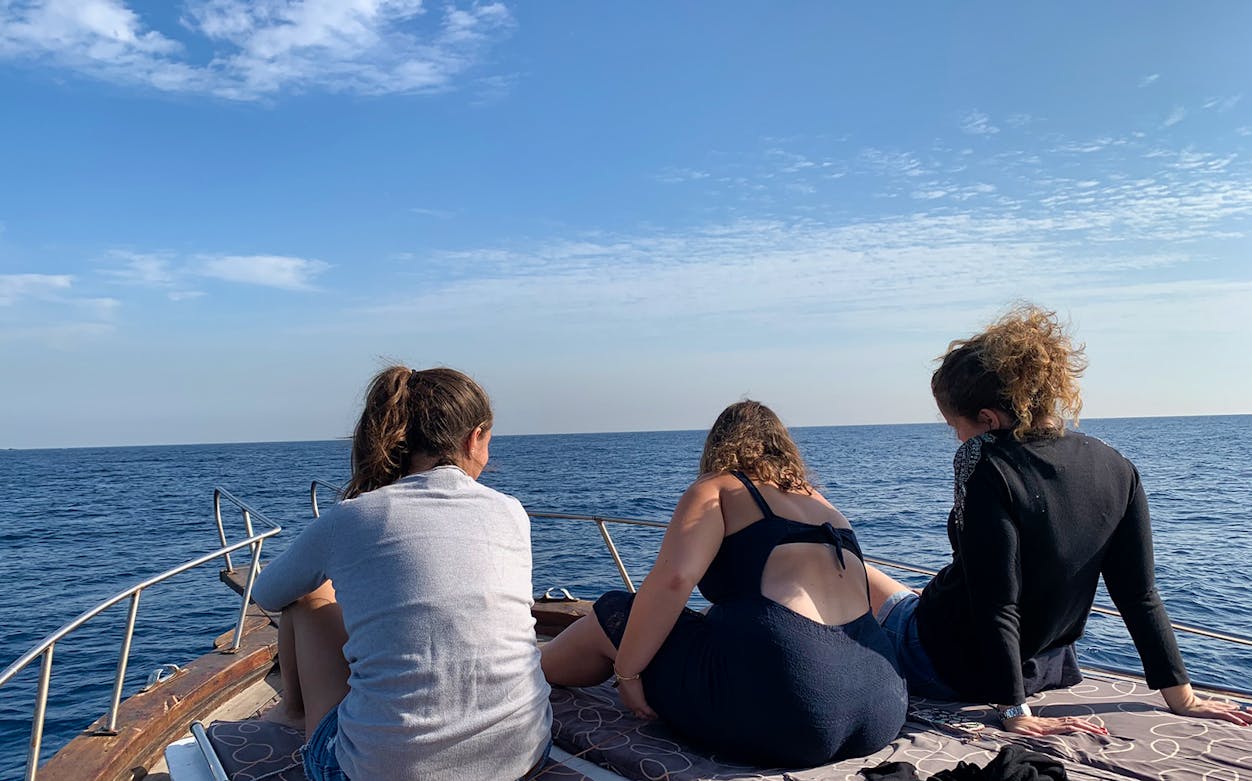 Tourists relaxing on a boat during a cruise from Catania, with a view of the sea.