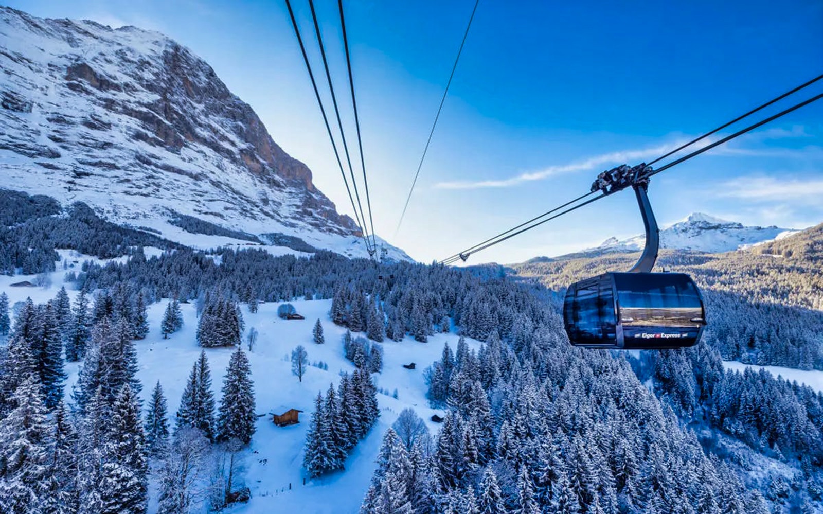 Cable car ascending snowy mountains from Grindelwald to Jungfraujoch.