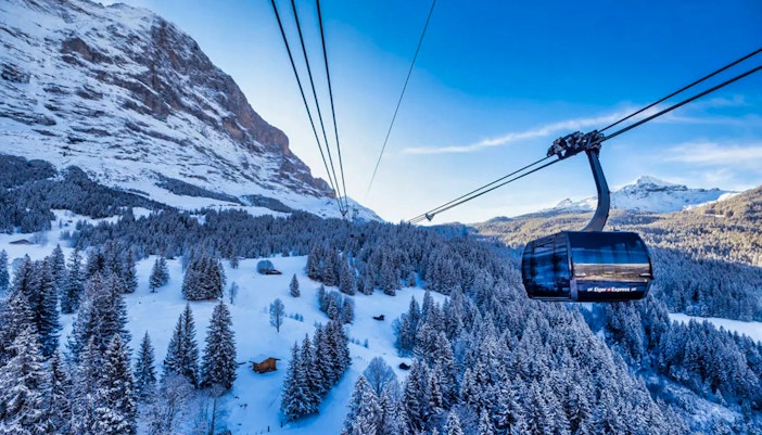 Cable car ascending snowy mountains from Grindelwald to Jungfraujoch.