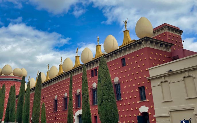 Dali Museum exterior with egg sculptures and cypress trees, Figueres, Spain.