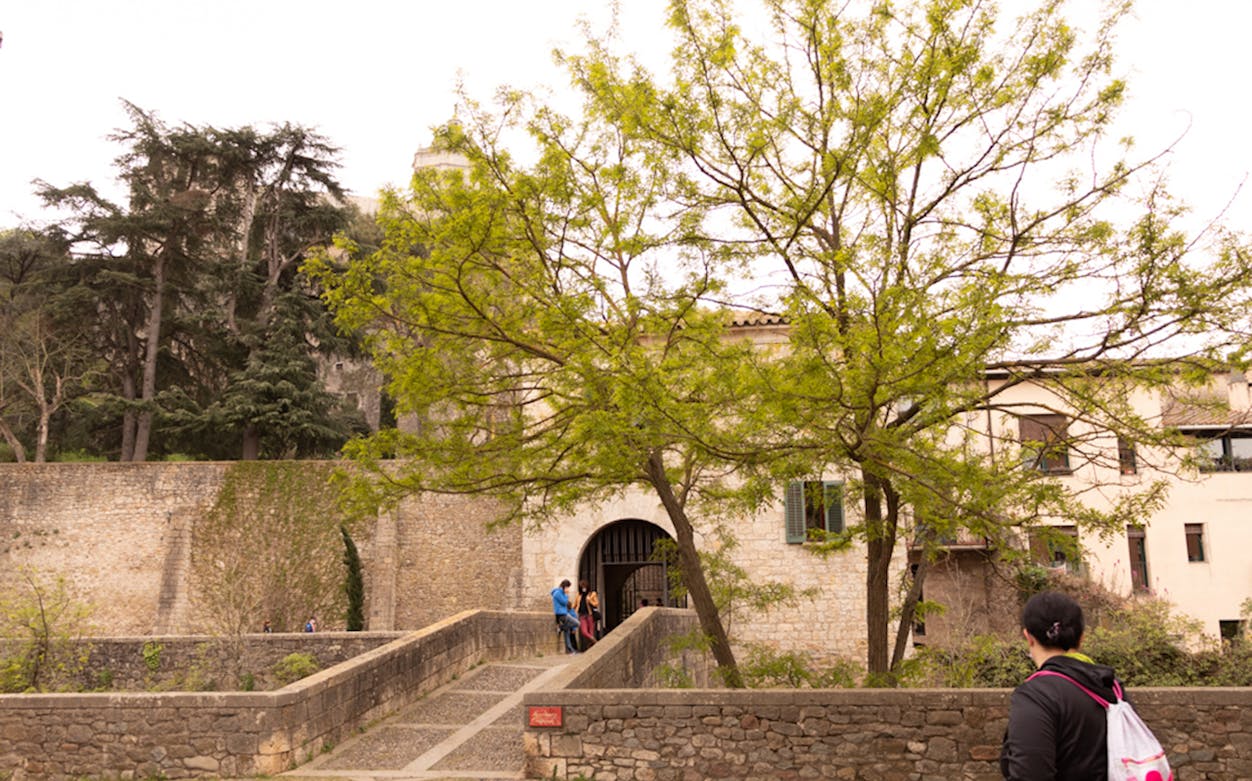 Entrance to Arab Baths in Girona with visitors approaching.