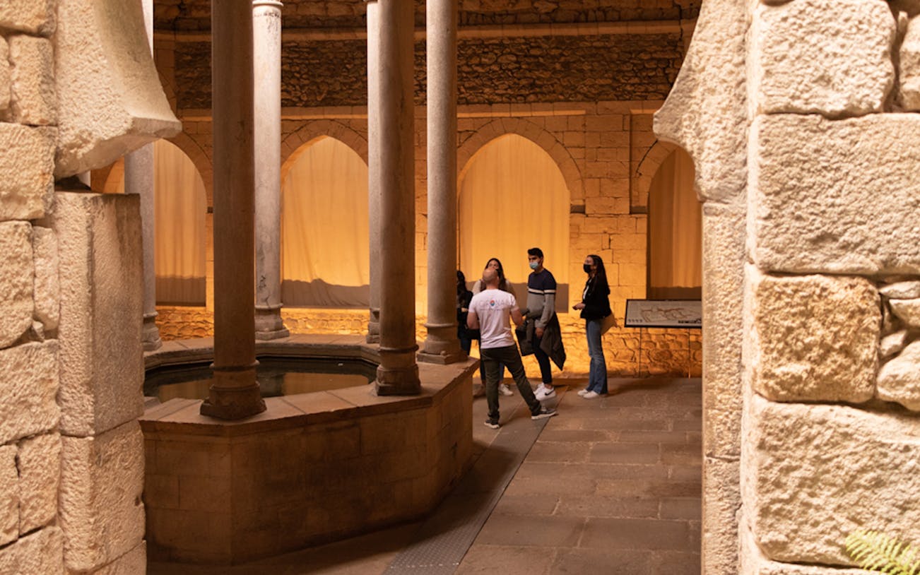 Visitors exploring the historic Arab Baths in Girona.