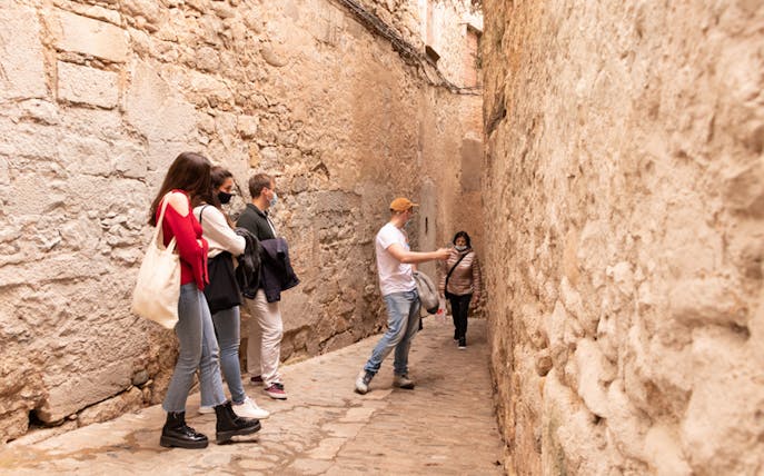 Tour group exploring narrow street in Jewish Quarter, Girona.