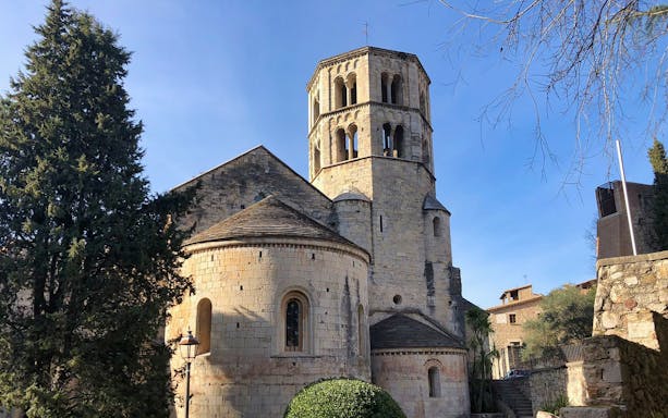 Medieval stone church with round tower in Girona, Spain.