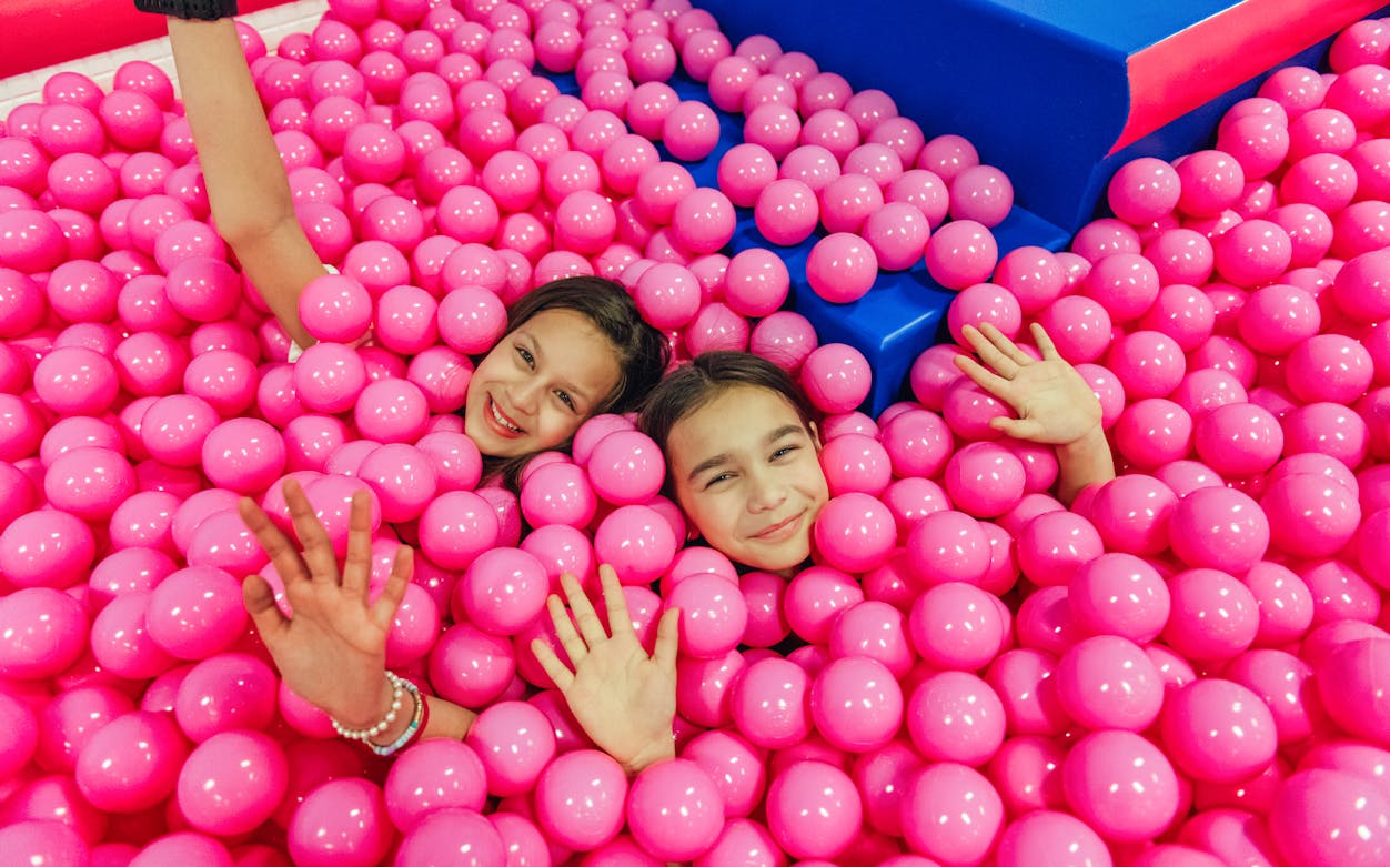 Children playing in a pink ball pit at Youseum, Westfield Mall of the Netherlands.