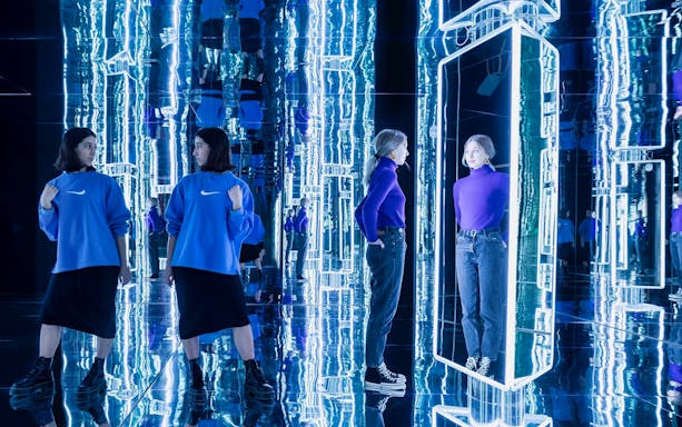 Visitors exploring mirrored art installation at Youseum.
