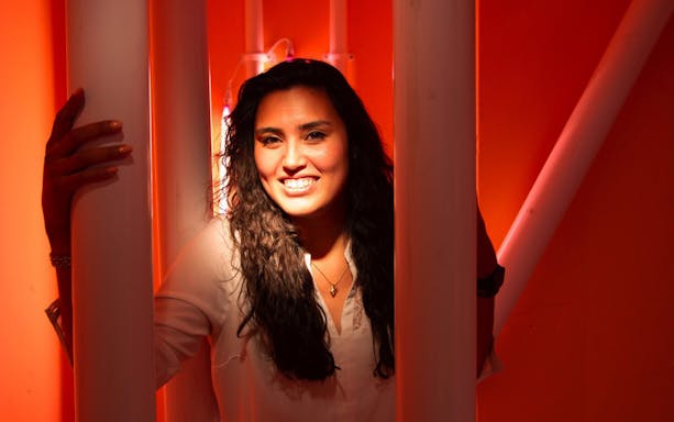 Person smiling in a vibrant orange room at Youseum.