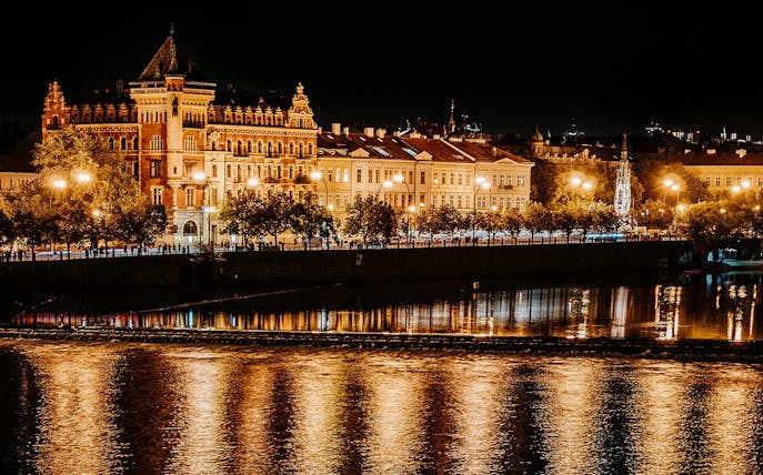 Prague riverside illuminated at night during After Dark Walking Tour.