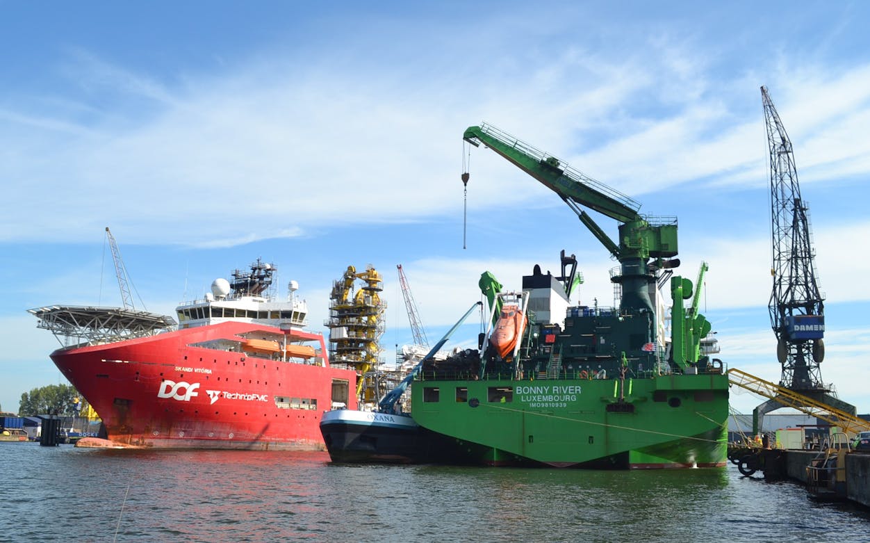 Docked ships and cranes at Port of Amsterdam during harbor tour.