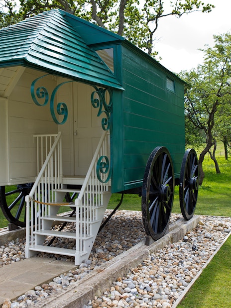 Historic carriage at Osborne House with visitor reading information sign.