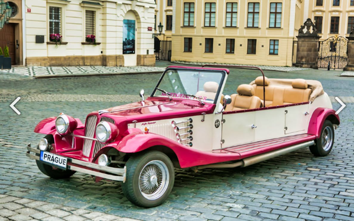 Vintage car parked on cobblestone street in Prague for sightseeing tour.