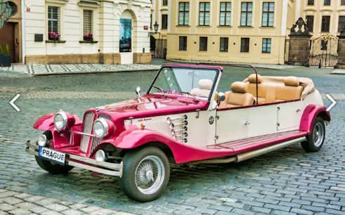 Vintage car parked on cobblestone street in Prague for sightseeing tour.