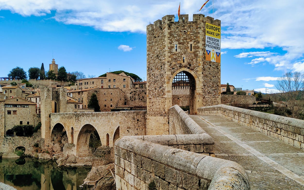 Medieval stone bridge and tower in Besalú, Spain, part of La Garrotxa Volcanic Zone hiking tour.