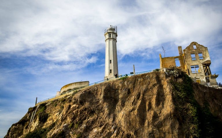 Alcatraz Island lighthouse and ruins on rocky cliff, San Francisco city tour.