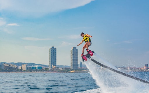 Flyboarding over the sea with Barcelona skyline in the background.