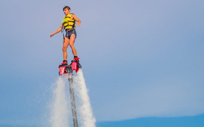 Person flyboarding over water in Barcelona.