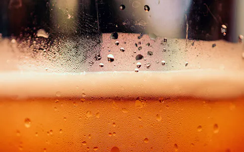 Close-up of beer with foam and condensation, part of a Prague beer tasting tour.