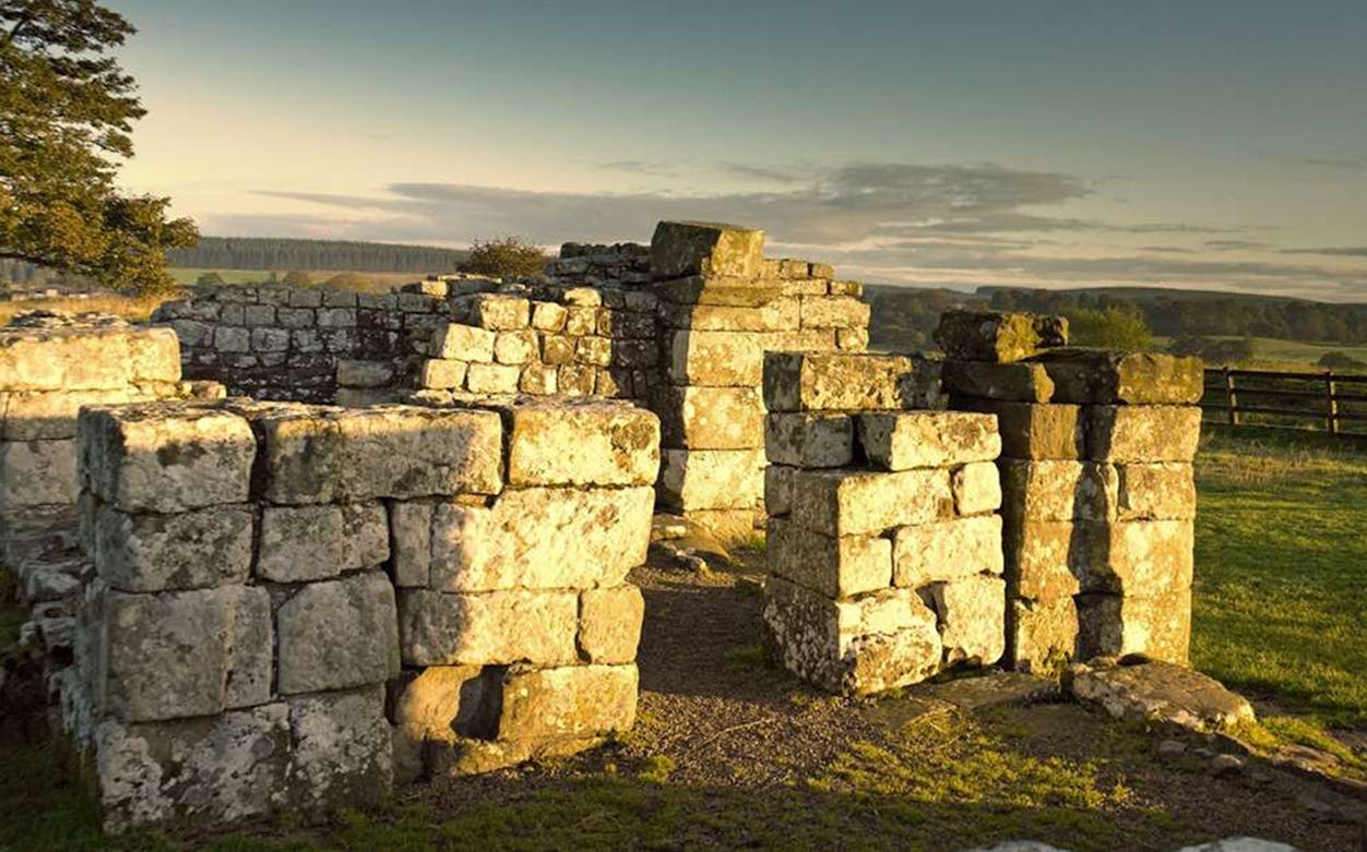 Birdoswald Roman Fort ruins with scenic countryside in the background.