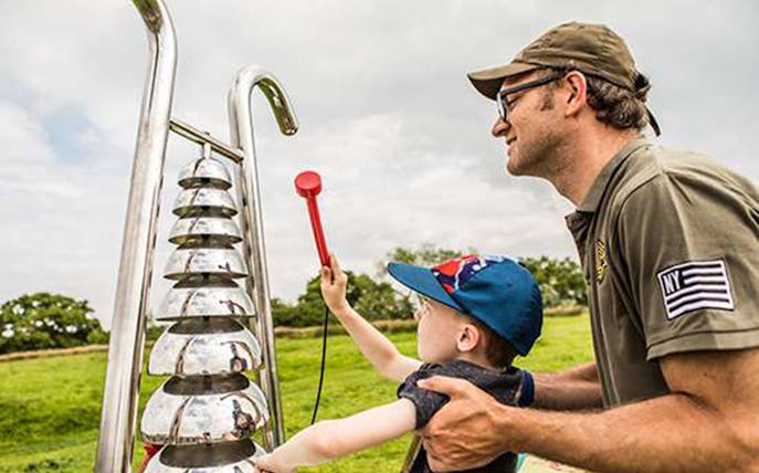 Child playing with outdoor musical instrument at Birdoswald Roman Fort.