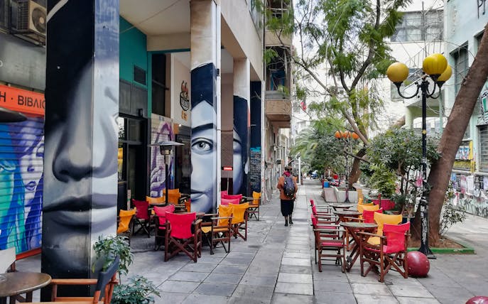 Street art and colorful café chairs in Exarcheia, Athens, during a walking tour.