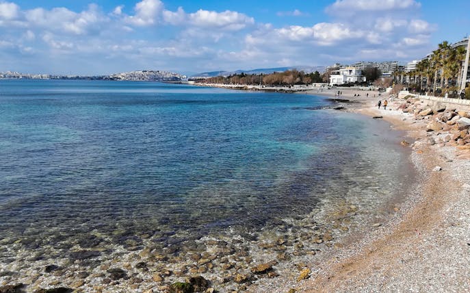 Athens seaside with clear blue water and beachfront promenade.