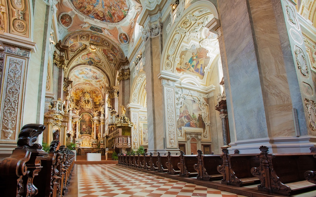 Interior of Klosterneuburg Monastery with ornate frescoes and wooden pews, Austria.