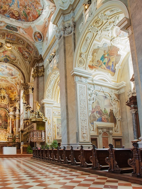 Interior of Klosterneuburg Monastery with ornate frescoes and wooden pews, Austria.