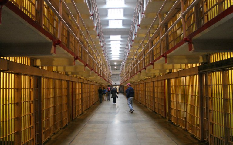 Alcatraz prison cell block interior with visitors walking through.