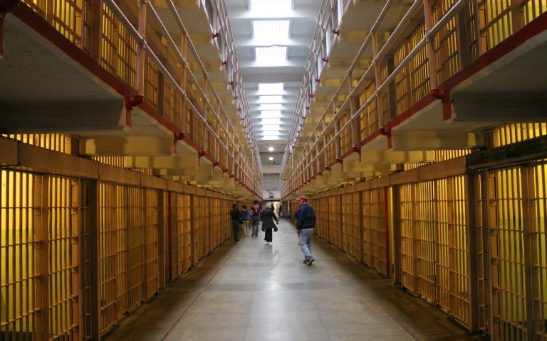 Alcatraz Island with historic prison building in San Francisco Bay during daytime.