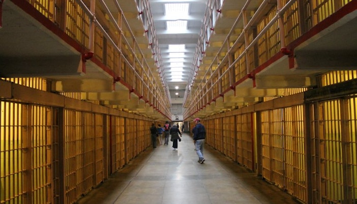 Alcatraz prison cell block interior with visitors walking through.