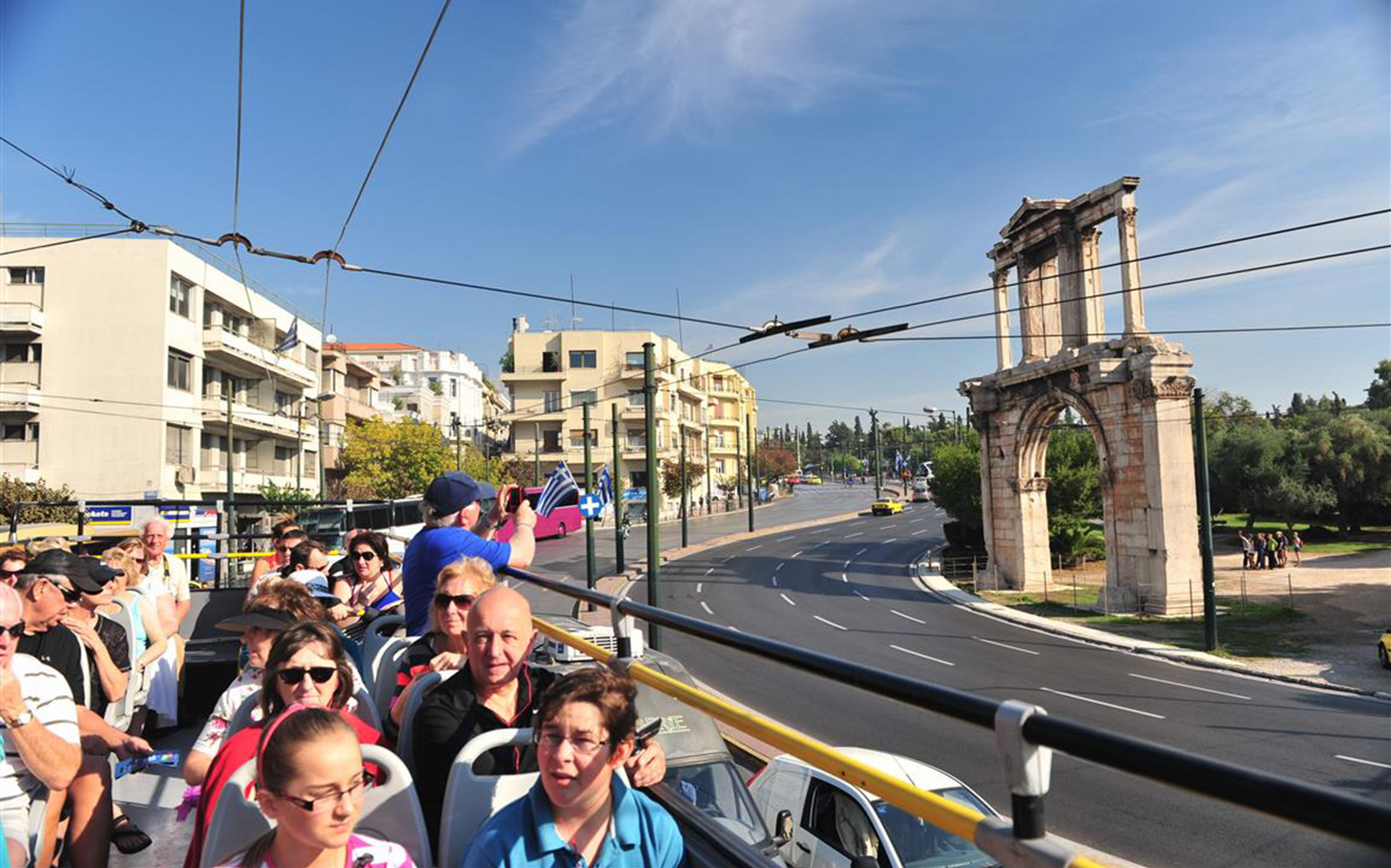 Double-decker bus tour in Athens passing Hadrian's Arch.