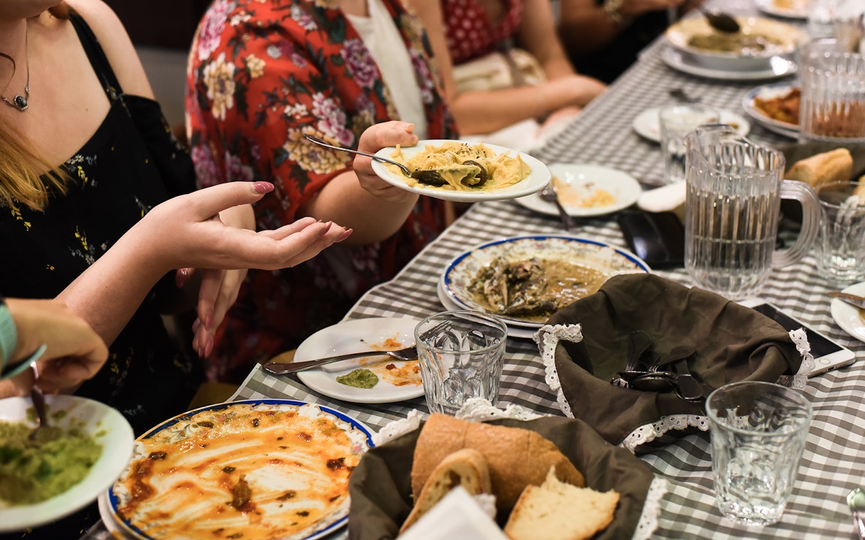 Group enjoying traditional Greek dishes at a table during Athens food tour.