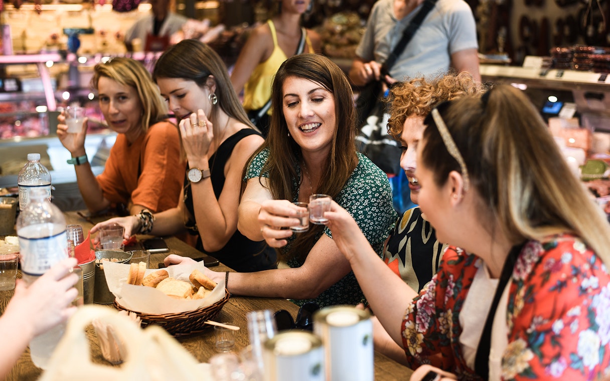 Group enjoying drinks and snacks on Athens food tour.