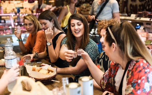 Group enjoying drinks and snacks on Athens food tour.