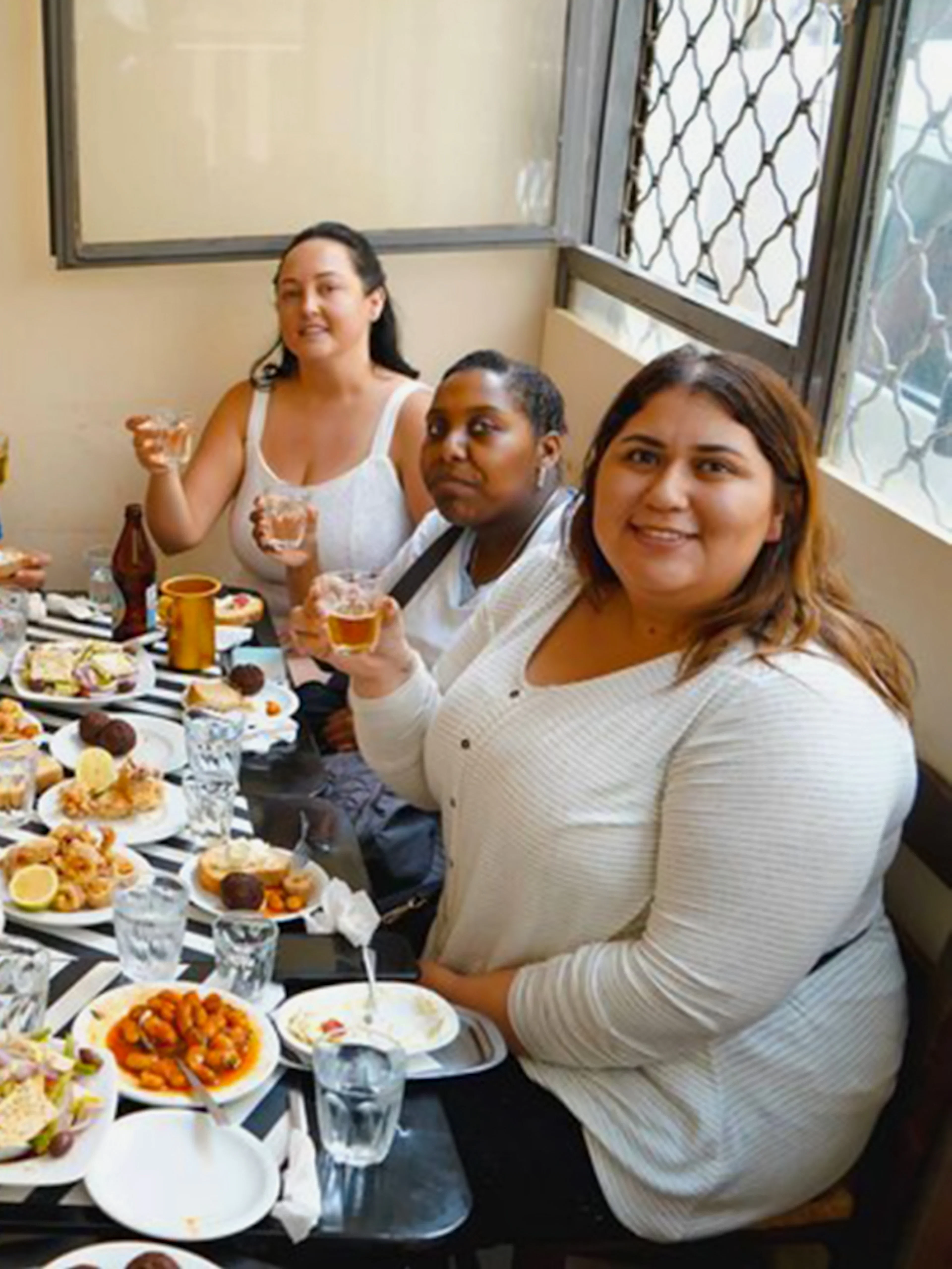 Group enjoying traditional Greek dishes on Athens street food tour.