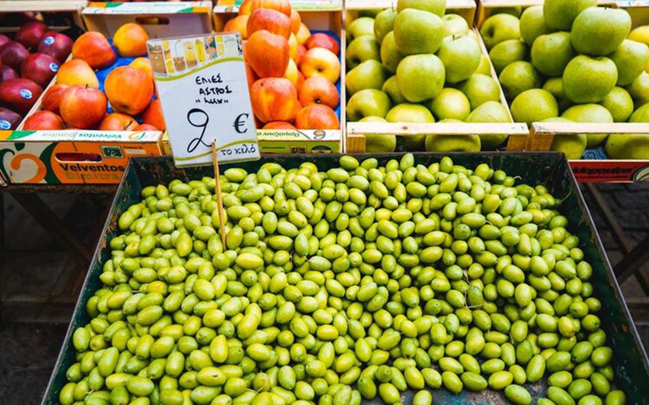 Green olives and fresh fruit at Athens food market.