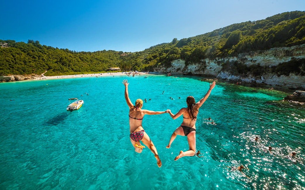 Jumping into clear waters on Paxos Antipaxos day cruise near Lakka village.