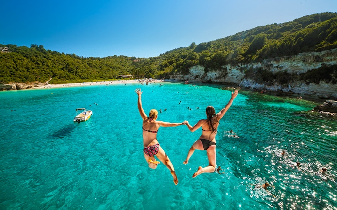 Jumping into clear waters on Paxos Antipaxos day cruise near Lakka village.