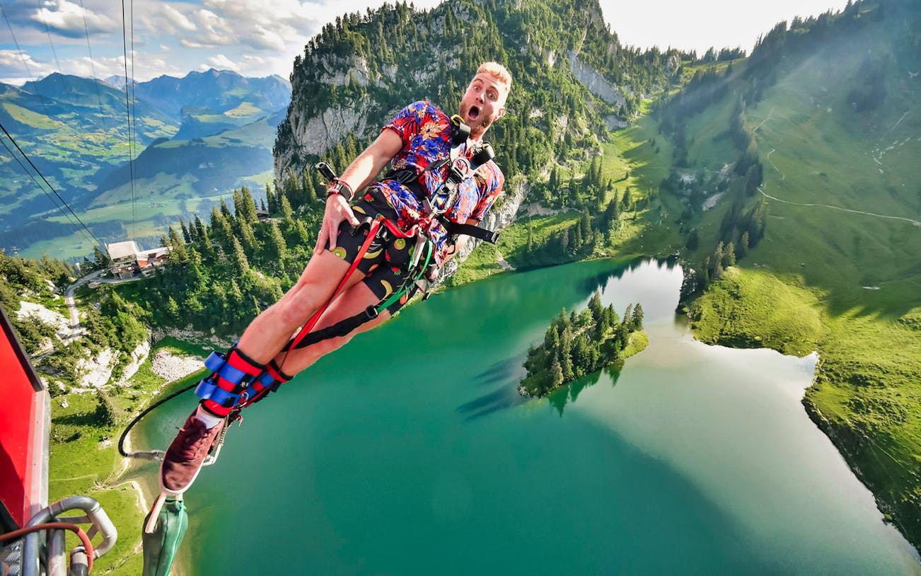 Bungy jumping over Stockhorn Lake with scenic mountain view, Switzerland.