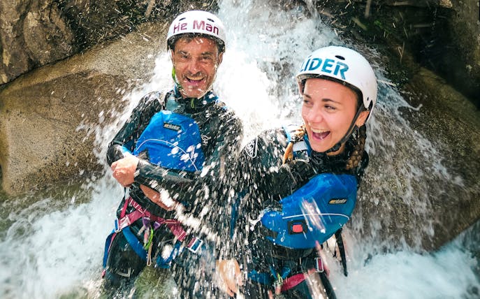Canyoning participants enjoying a waterfall during Grimsel experience near Interlaken.