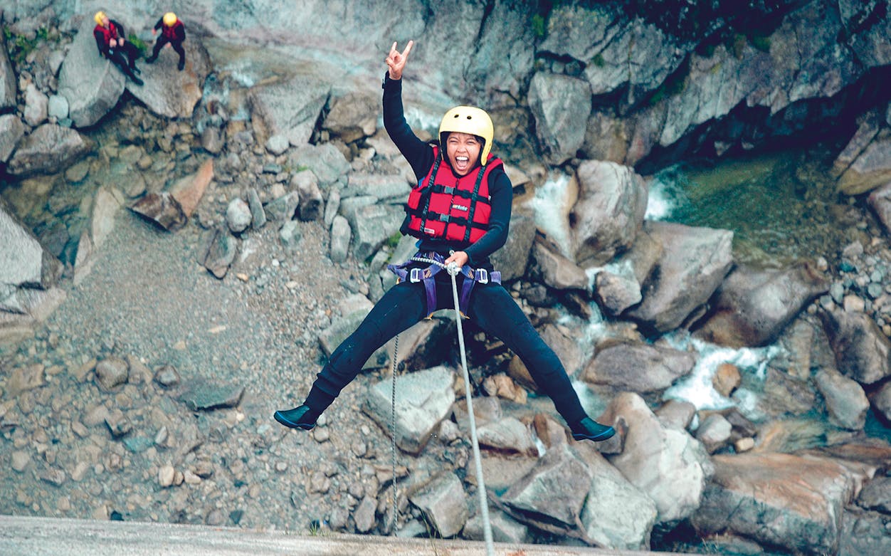 Canyoning participant descending a rock face in Grimsel, near Interlaken.