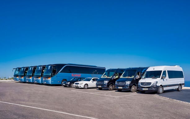 Tour buses and vans ready for the Full Day Santorini Volcano & Oia Sunset Tour.
