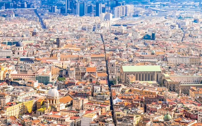 Aerial view of Naples cityscape, highlighting historic architecture and urban layout.