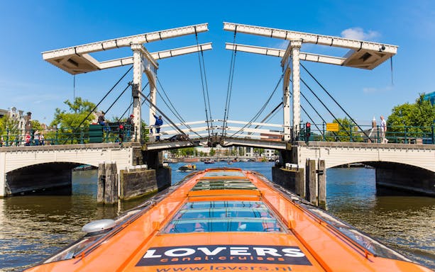 Amsterdam canal cruise boat approaching Magere Brug bridge.