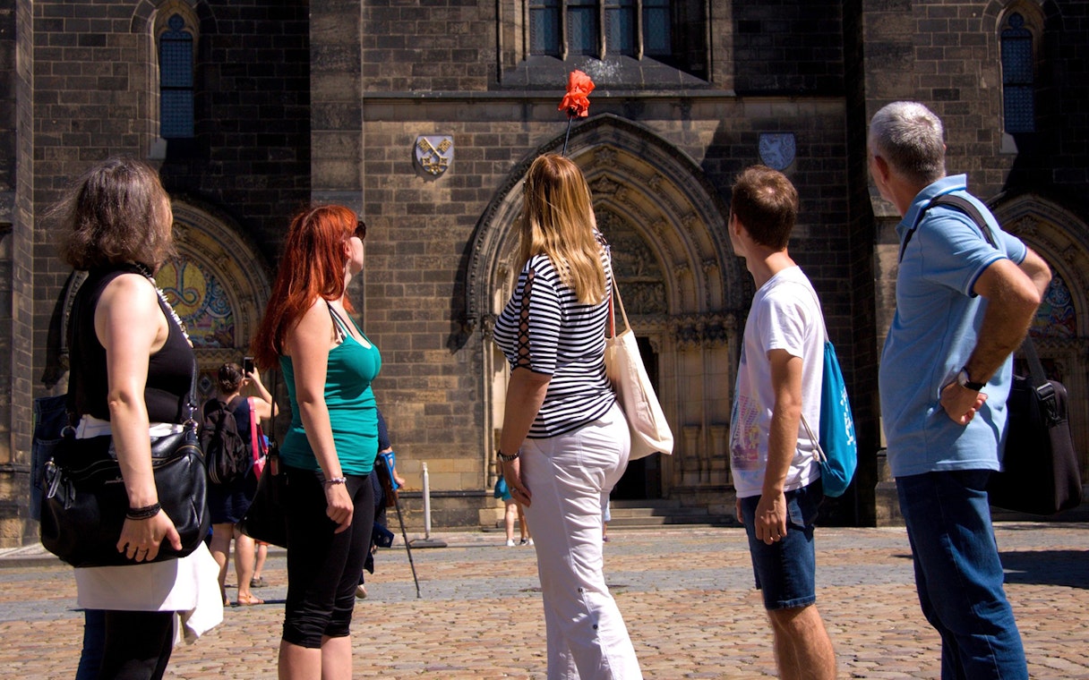 Tourists exploring Vyšehrad Castle's historic entrance in Prague.